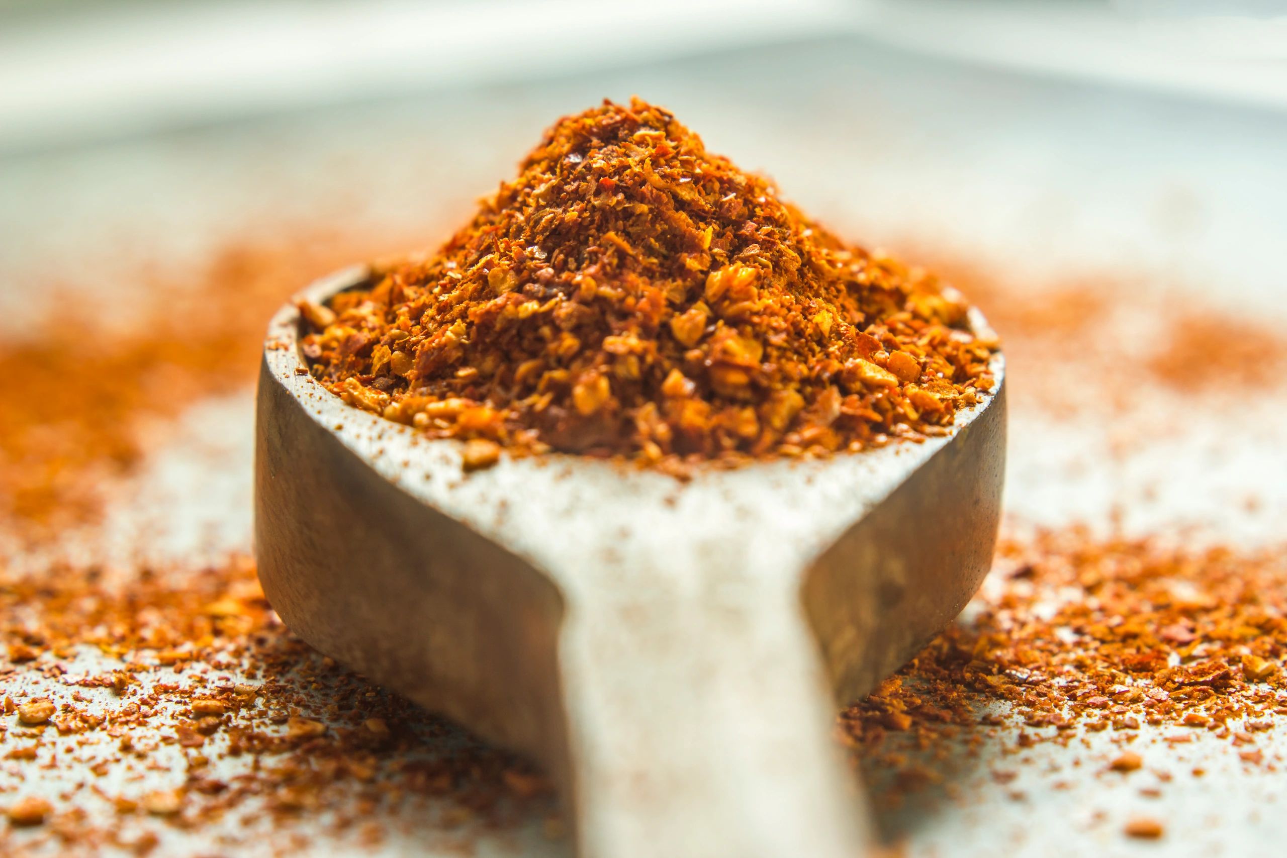Close-up of red chilli powder in a spoon